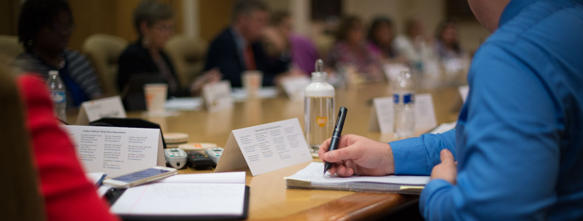 Employees at conference table in committee meeting