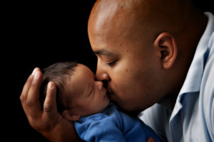 Man embraces newborn son
