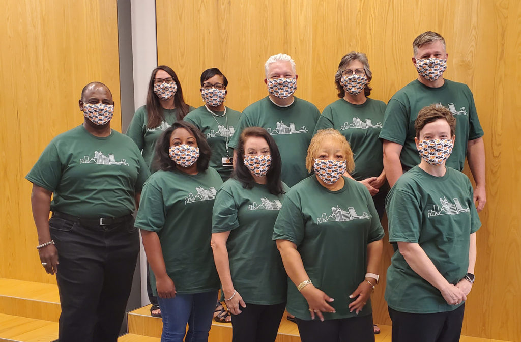 Ten human resources leaders take a photo wearing matching green tshirts and UTHSC face masks
