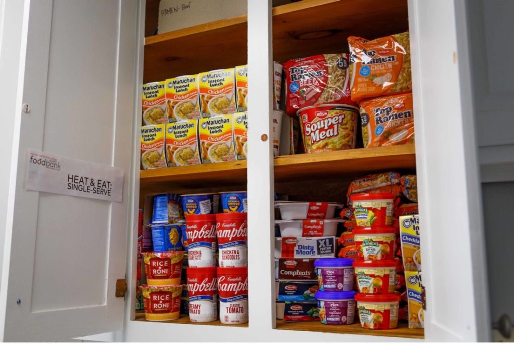 A cupboard is stacked with nonperishable food items